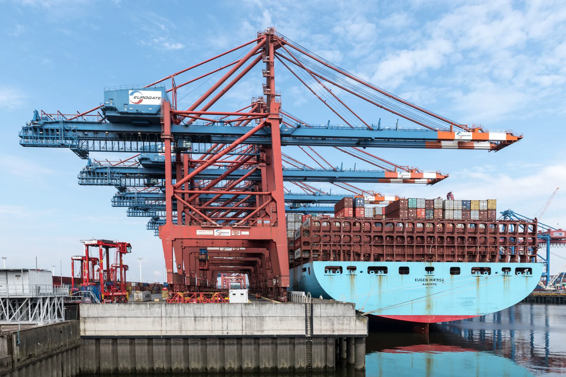 Stock photograph of a container ship and port loading cranes.